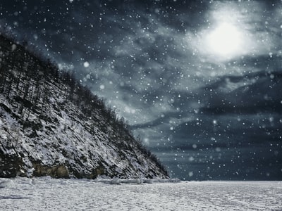 下雪在多云的夜空的山。
